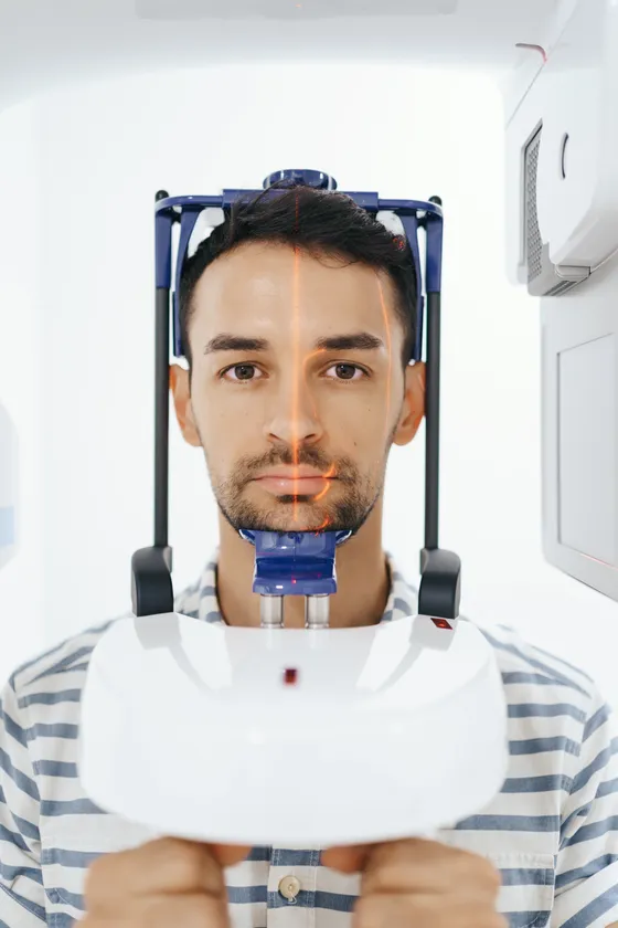 Pacient pri CBCT snímkovaní, s navádzacím laserovým krížom na tvári